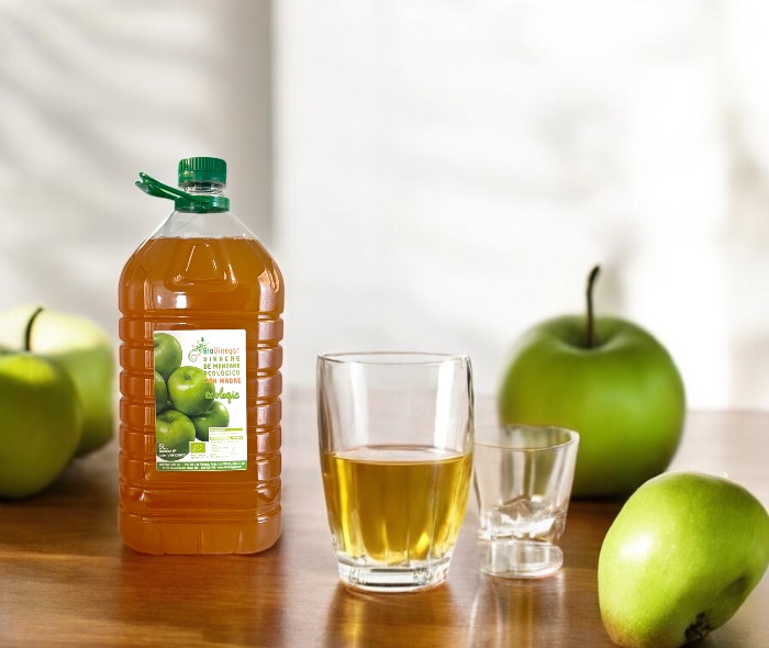 Garrafa de 5 litros de vinagre de manzana ecológico con madre y un vaso de agua con vinagre de manzana